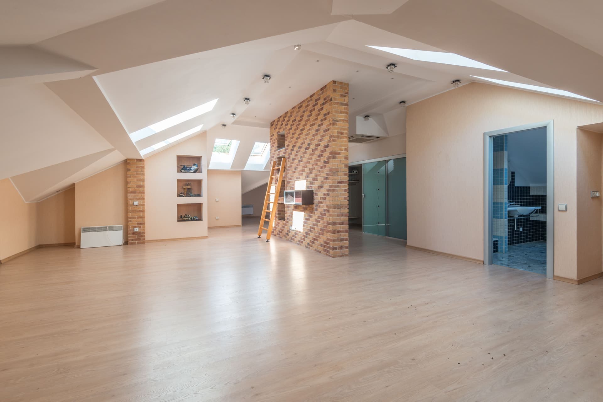 A wooden pull-down attic ladder folded into a ceiling opening