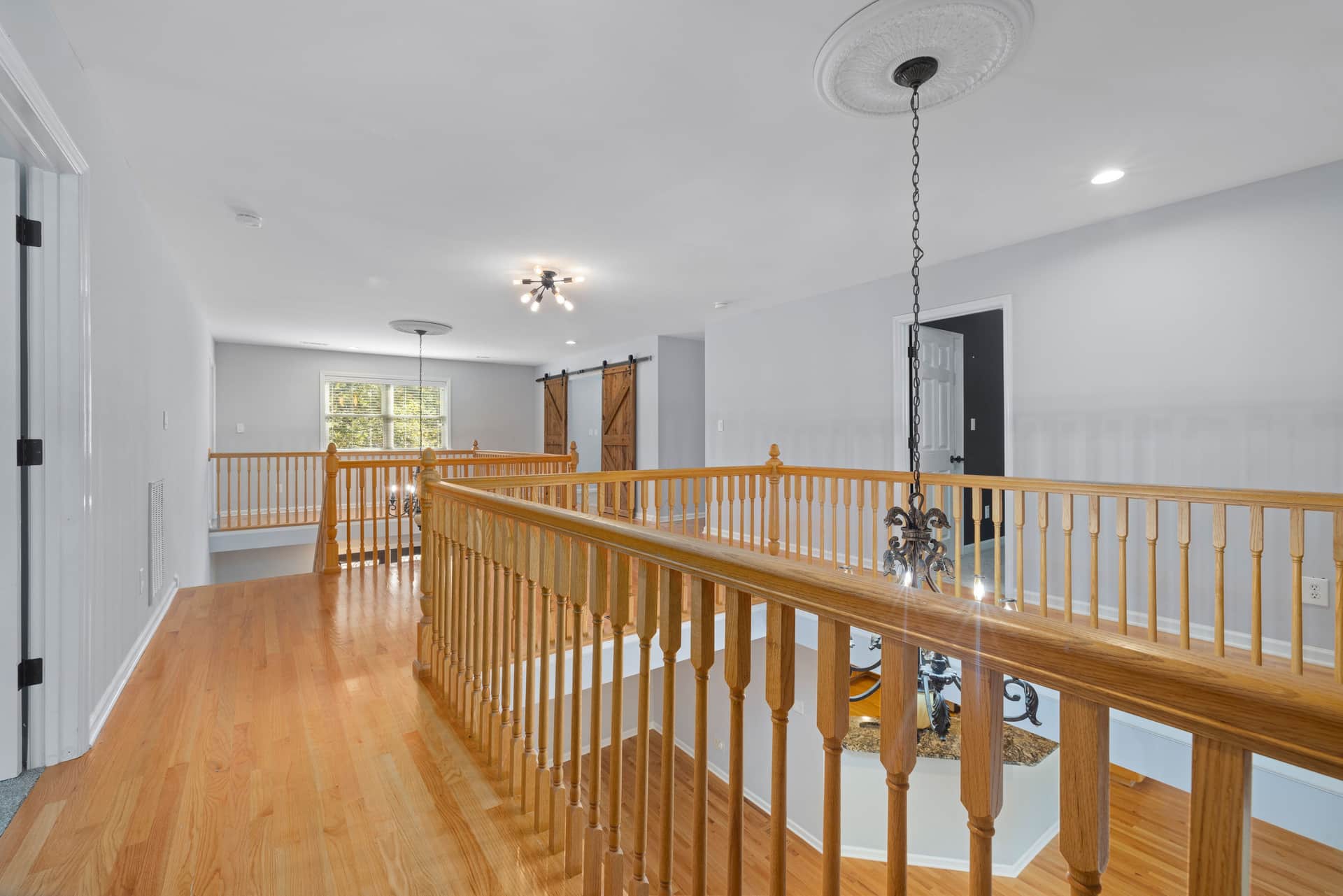 An upstairs landing and staircase in cold daylight with a ceiling above