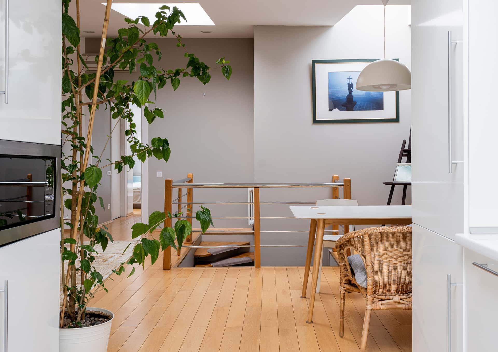A bright attic room with wooden floors and a staircase