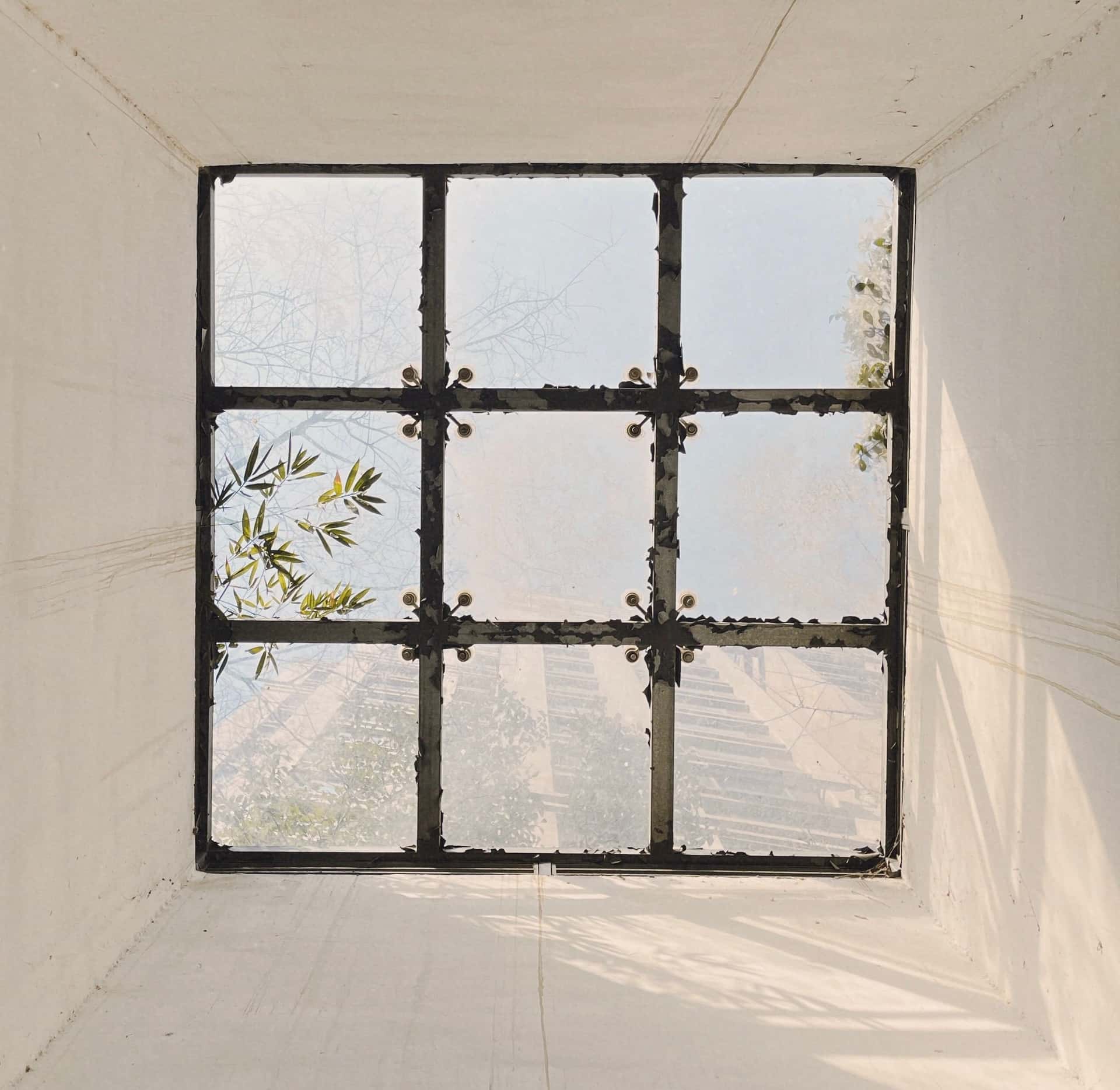 A square framed hatch opening in a white ceiling seen from below