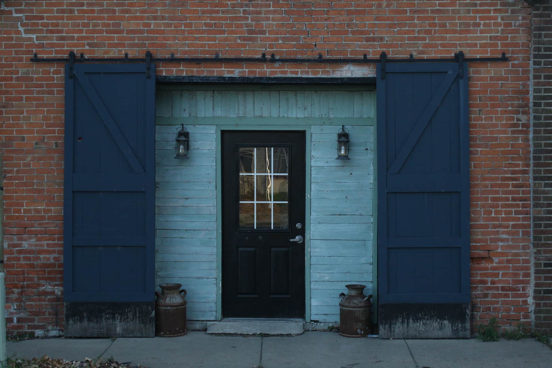 A sliding barn door in a brick wall, seen square-on