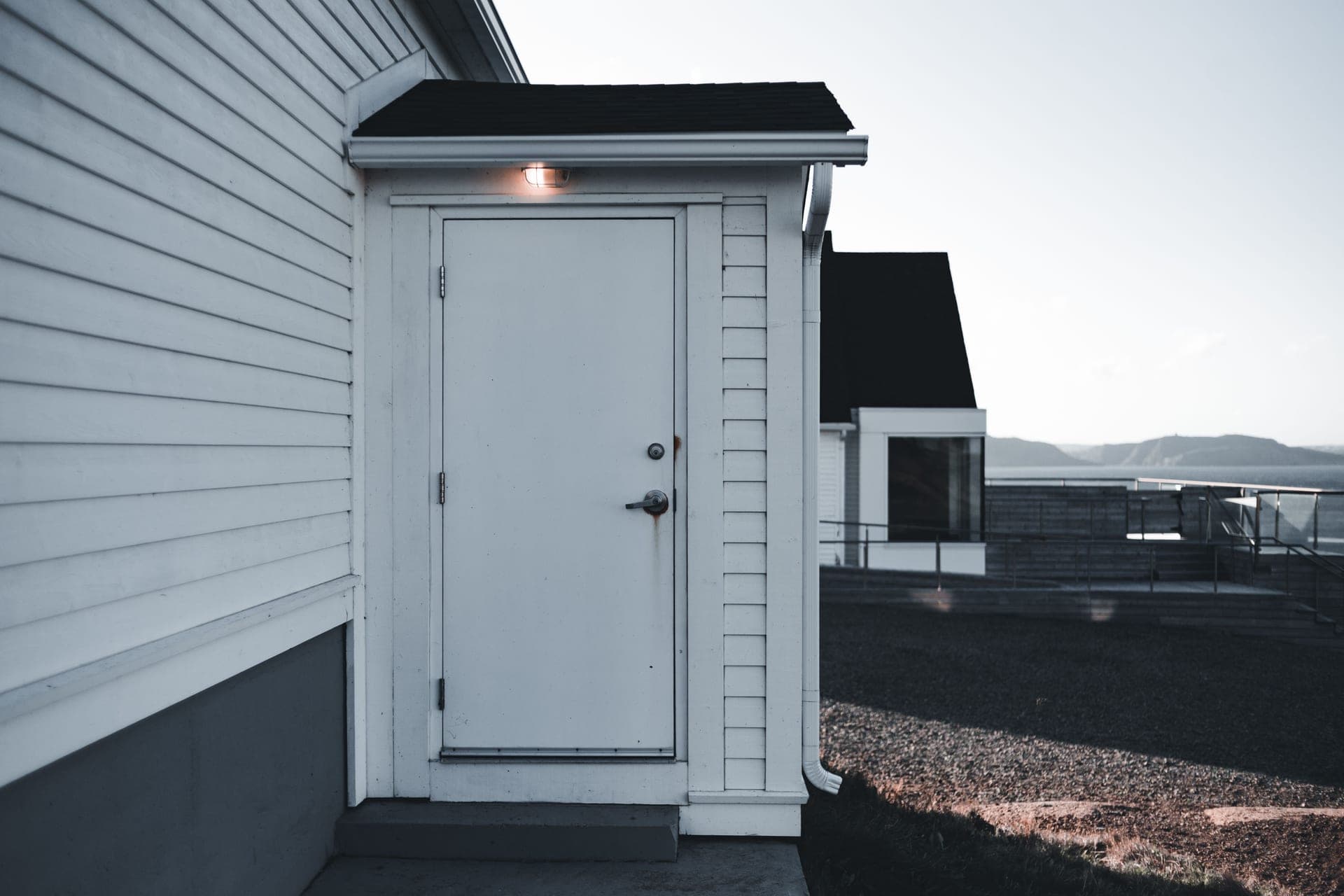 A white exterior door above a concrete step
