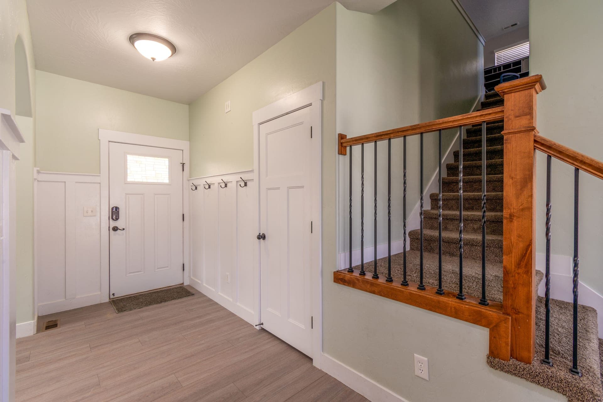 A white painted entry door closed in its frame, seen from the hallway inside