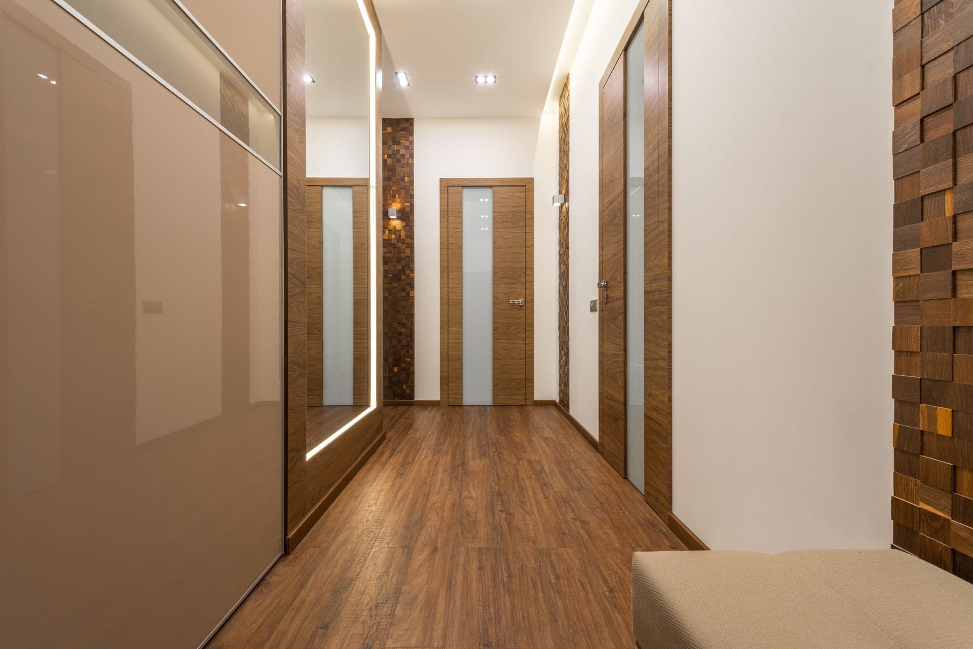 A hallway lined with closed interior doors above a wood floor