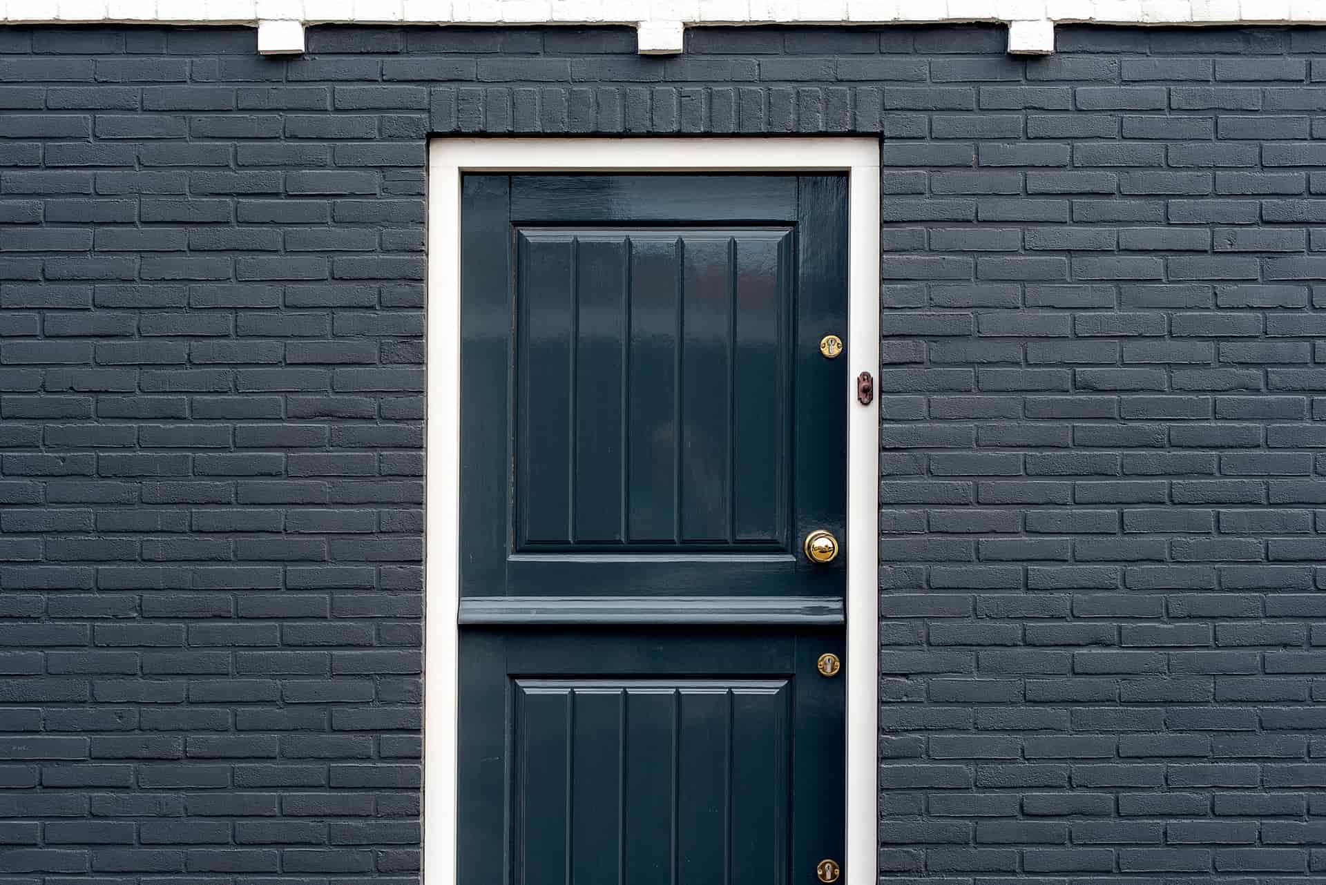 Close-up of the bottom edge of a door against a metal threshold, showing the seal line