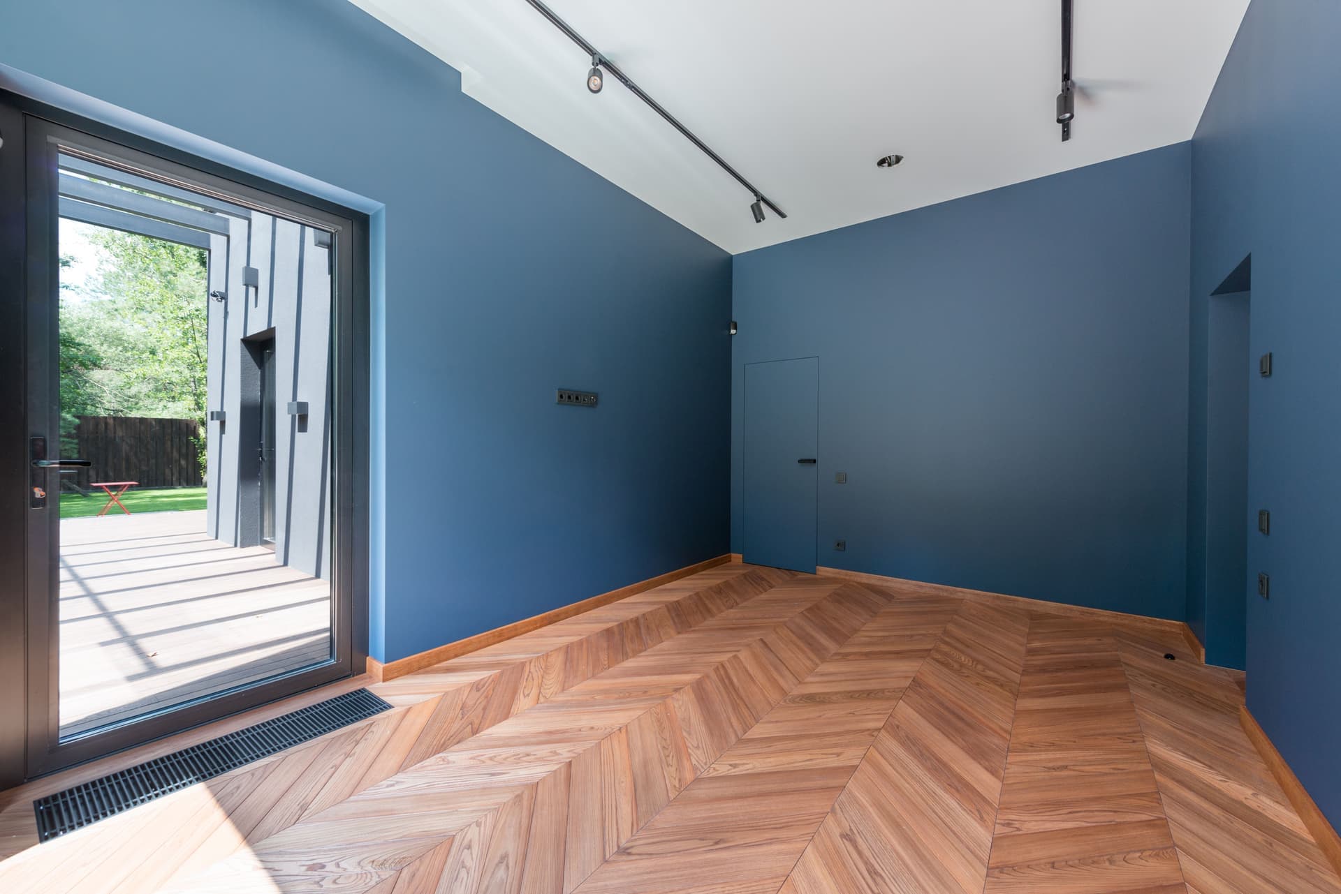 A bare interior room with wooden flooring and a closed door