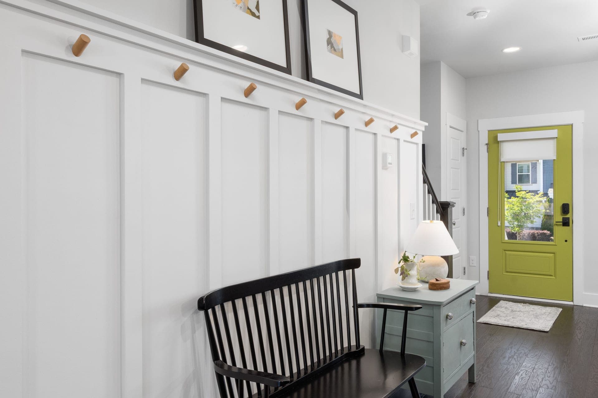 A green prehung entry door in a white frame, seen from inside an entryway