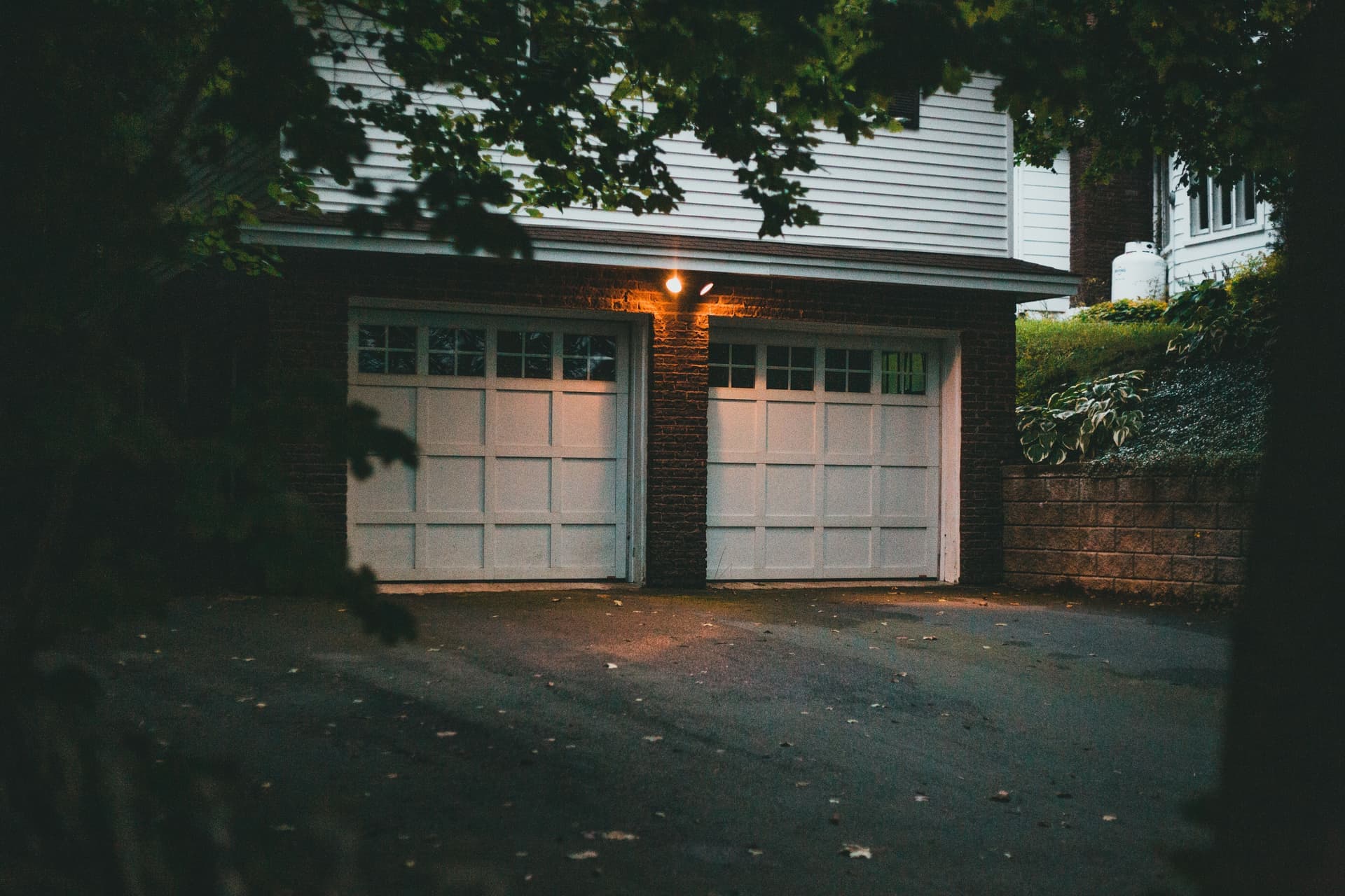 A white residential garage door on a suburban home