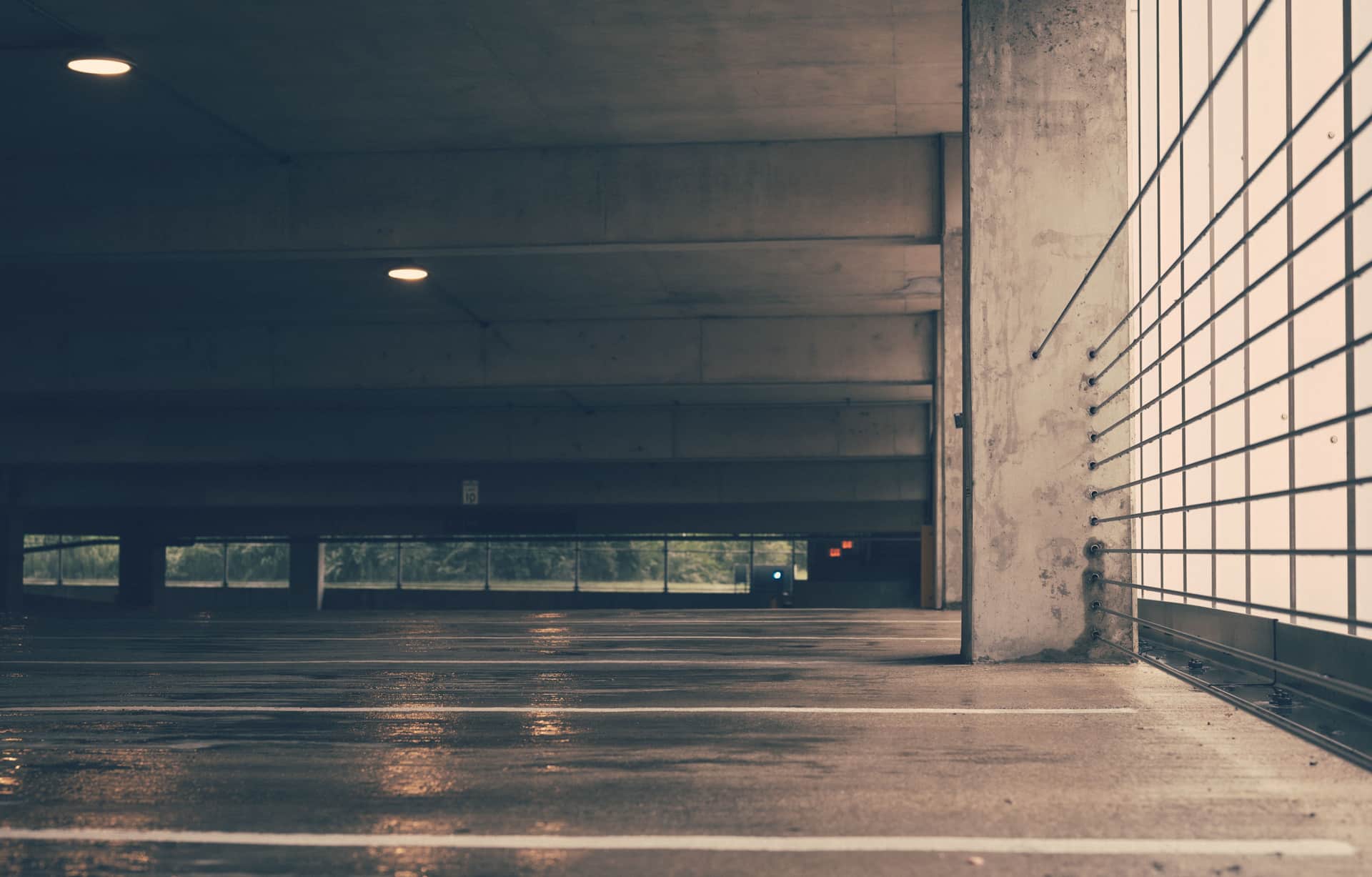A black rubber threshold strip bonded to a garage floor across the door opening
