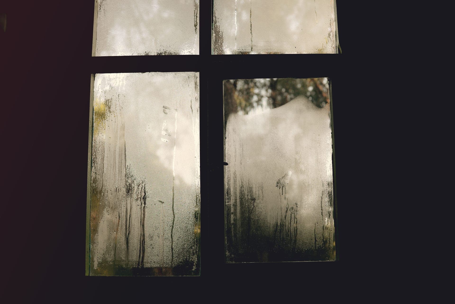 A misted window pane with cold daylight behind it