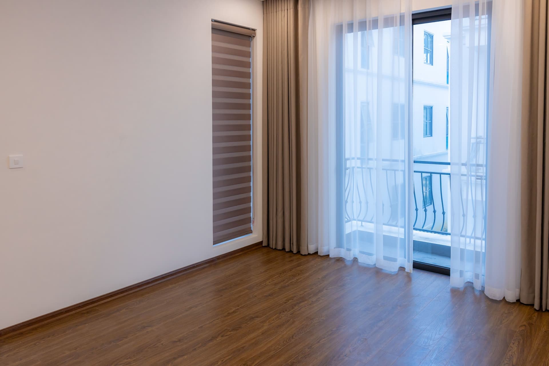 A rented apartment window with an old painted sash and a removable putty seal along the frame